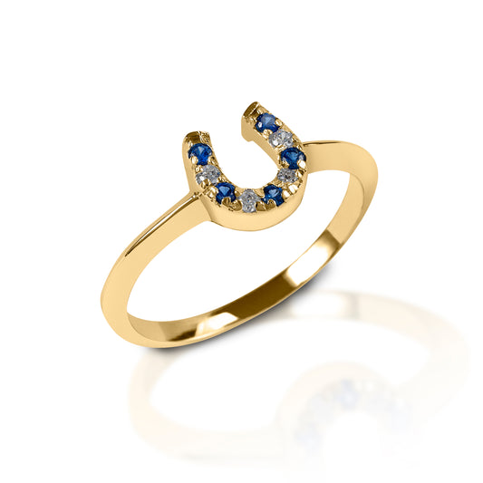 The Kelly Herd Blue & Clear Horseshoe Ring is a delicate sterling 14k yellow or white Gold ring enhanced with blue stones and diamonds set in a horseshoe. Perfect for taking a little luck into the ring with you!  Features      Delicate horseshoe ring     Sapphire and diamond gemstones     Available in white gold, or yellow gold     Matching earrings and necklace available     8mm wide