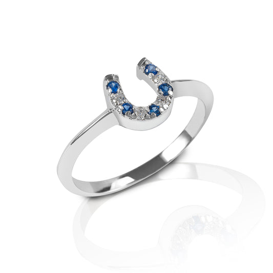 The Kelly Herd Blue & Clear Horseshoe Ring is a delicate sterling 14k yellow or white Gold ring enhanced with blue stones and diamonds set in a horseshoe. Perfect for taking a little luck into the ring with you!  Features      Delicate horseshoe ring     Sapphire and diamond gemstones     Available in white gold, or yellow gold     Matching earrings and necklace available     8mm wide