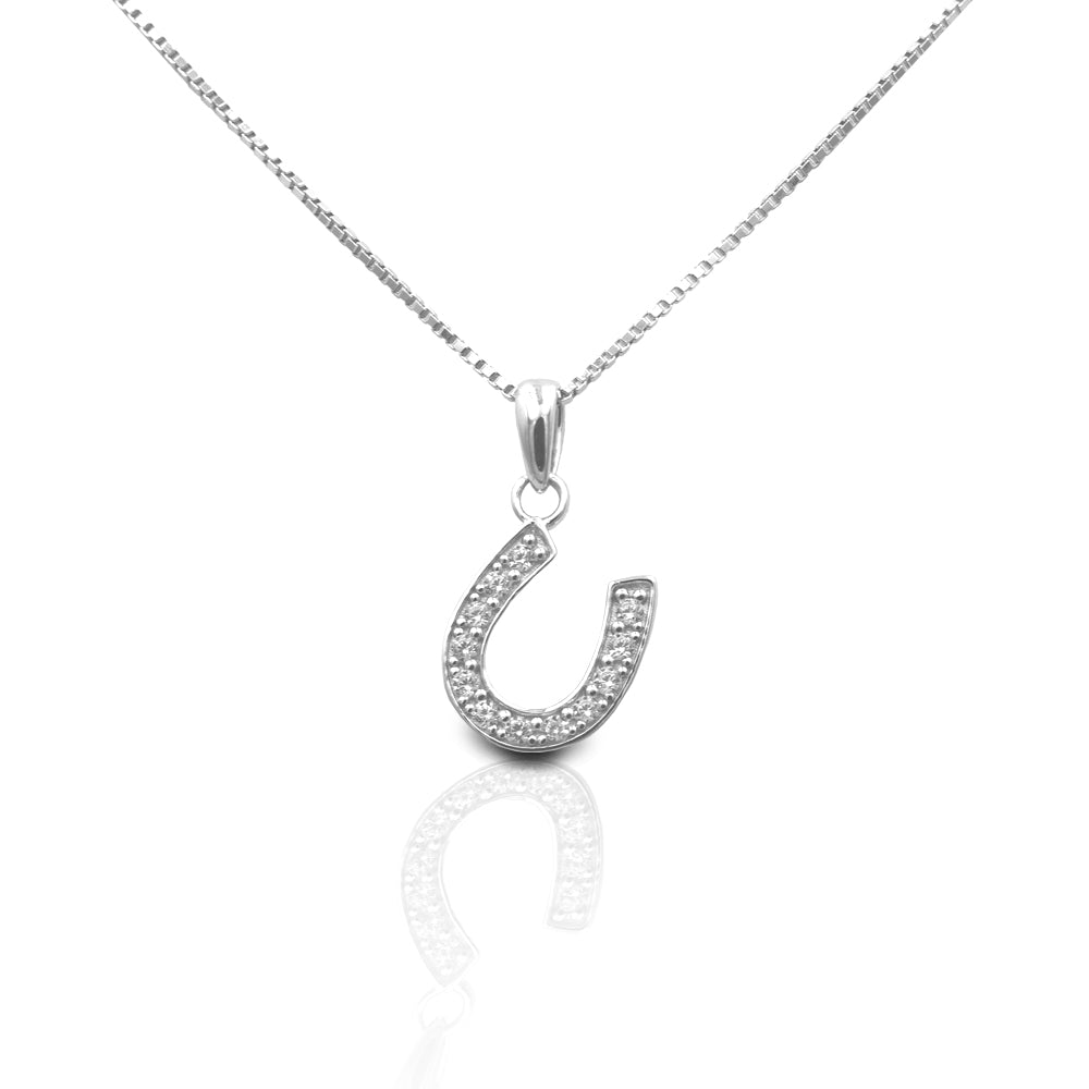The Kelly Herd Large Clear Dangle Horseshoe Necklace features a beautiful offset sterling silver horseshoe design enhanced with clear cubic zirconia stones. This is the larger version of one of our best selling pendants. It's perfect for taking a little luck into the ring with you. Comes with a 16" - 18" adjustable box chain.  