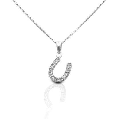 The Kelly Herd Large Clear Dangle Horseshoe Necklace features a beautiful offset sterling silver horseshoe design enhanced with clear cubic zirconia stones. This is the larger version of one of our best selling pendants. It's perfect for taking a little luck into the ring with you. Comes with a 16" - 18" adjustable box chain.  