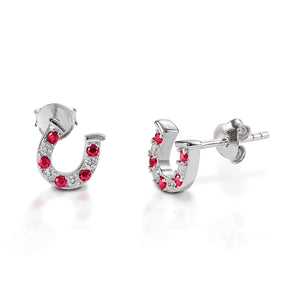 Kelly Herd Red & Clear Horseshoe Earrings are delicate gold horseshoes enhanced with rubies and diamonds. Perfect for taking a little luck into the ring with you!  Features      Delicate horseshoe earrings     Rubies and diamonds     Available in white, or yellow 14k gold     Matching ring and necklace available     8mm x 8mm