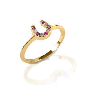 The Kelly Herd Red & Clear Horseshoe Ring is a delicate gold ring enhanced with rubies and diamond gemstones set in a horseshoe. Clean and understated, this ring is perfect for taking a little luck into the ring with you!  Features      Delicate horseshoe ring     Ruby and diamonds     Available in white, or yellow 14k gold     Matching earrings and necklace available     8mm wide