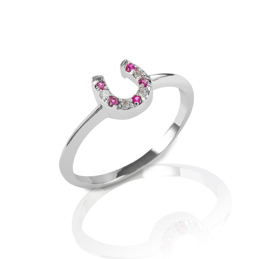 The Kelly Herd Red & Clear Horseshoe Ring is a delicate gold ring enhanced with rubies and diamond gemstones set in a horseshoe. Clean and understated, this ring is perfect for taking a little luck into the ring with you!  Features      Delicate horseshoe ring     Ruby and diamonds     Available in white, or yellow 14k gold     Matching earrings and necklace available     8mm wide