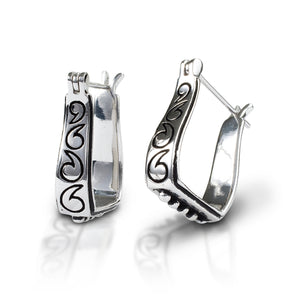 Kelly Herd Engraved Stirrup Earrings are reminiscent of hand tooled leather. Styled like hoops, but in the shape of a Western stirrup, the engravings stand out in black against sterling silver.  Features      Sterling silver earrings     Western stirrup shape     Black engraving     Hoop style     24mm x 12mm   