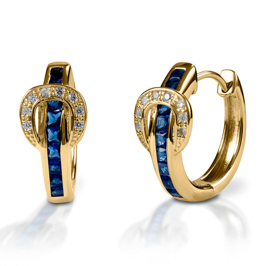 A fun take on classic hoop earrings! Kelly Herd Contemporary Buckle Earrings take the form of a simple show belt. Made of white or yellow gold, the "belt" is set with square pavé sapphires, and the buckle has round diamonds.  Features      Buckle and belt shaped hoop earrings     Sapphire and diamonds     White or yellow gold     8mm x 17mm