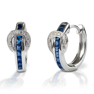 A fun take on classic hoop earrings! Kelly Herd Contemporary Buckle Earrings take the form of a simple show belt. Made of sterling silver, the "belt" is set with square pavé blue CZ, and the buckle has round clear stones.  Features      Buckle and belt shaped hoop earrings     Blue and Clear Cubic Zirconia Stones     Sterling Silver     8mm x 17mm