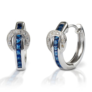 A fun take on classic hoop earrings! Kelly Herd Contemporary Buckle Earrings take the form of a simple show belt. Made of white or yellow gold, the "belt" is set with square pavé sapphires, and the buckle has round diamonds.  Features      Buckle and belt shaped hoop earrings     Sapphire and diamonds     White or yellow gold     8mm x 17mm