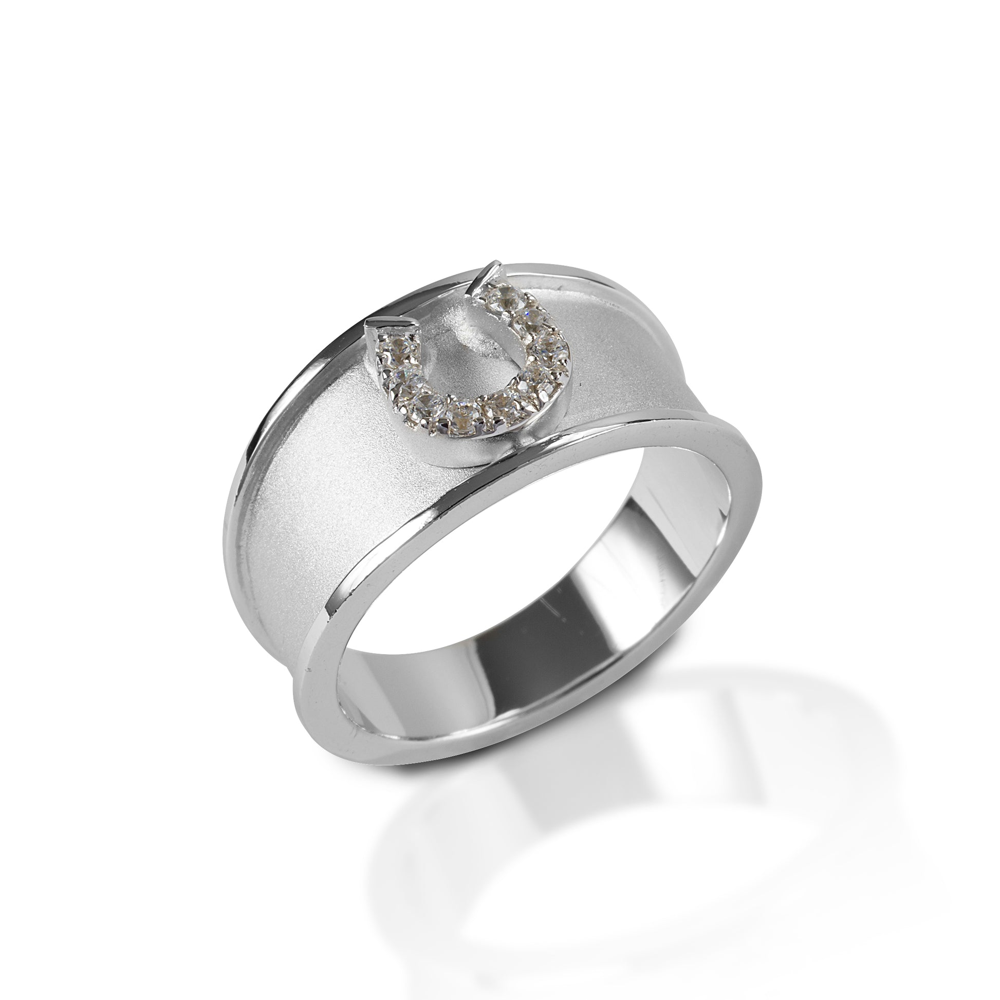 The Kelly Herd Wide Band Horseshoe Ring features a 9mm wide band of brushed sterling silver with a raised edge.  In the center sits a perfectly formed tiny horseshoe with pave cubic zirconia stones.  This ring is perfect for people who actually ride; no large single stones to catch on every piece of tack!   Features      Wide brushed band     Raised edge     Sterling silver     Clear cubic zirconia horseshoe