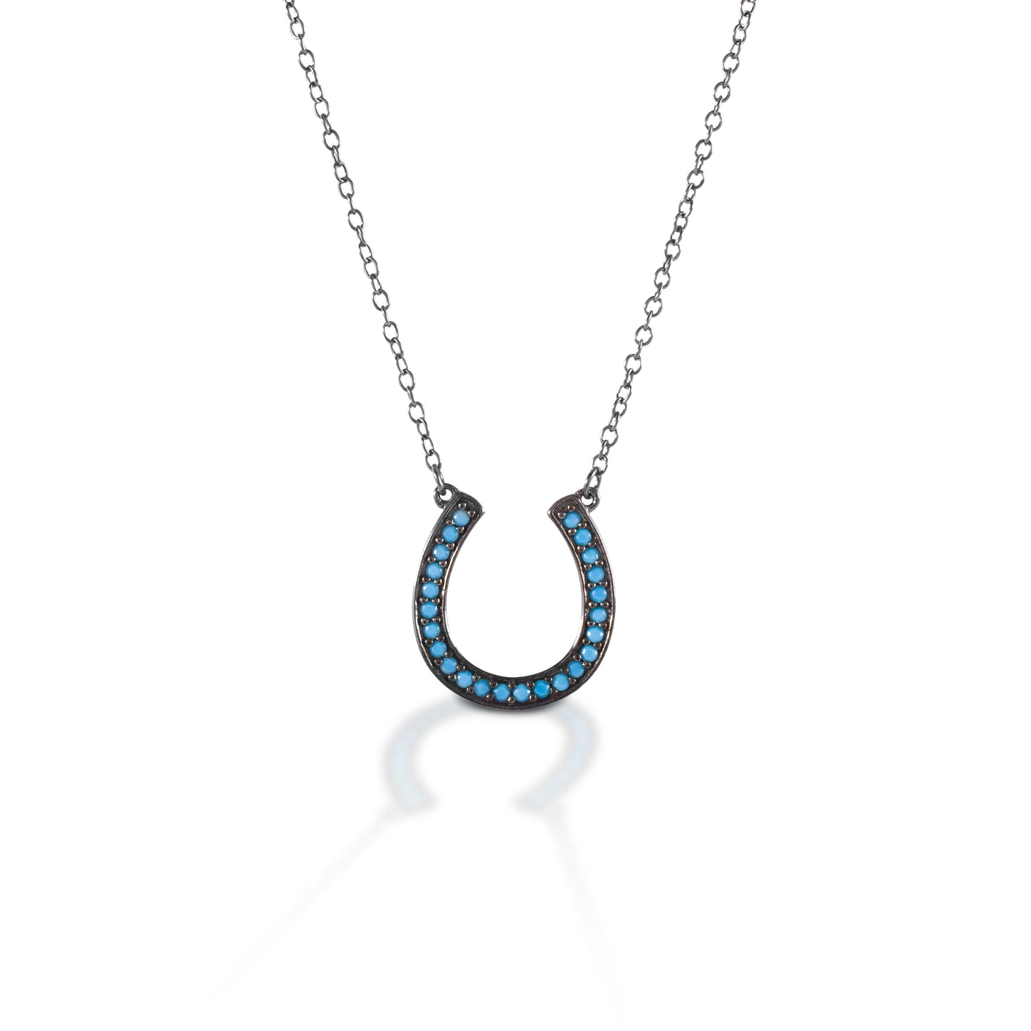 The Kelly Herd Turquoise Horseshoe Necklace stands out from the pack with its glowing turquoise colored stones against dark burnished sterling silver setting. Dare to be just a little different! Comes with a 16"-18" adjustable chain.  Features      Horseshoe pendant necklace     Dark burnished sterling silver     Blue stones     Adjustable 16-18" chain     11mm x 11mm