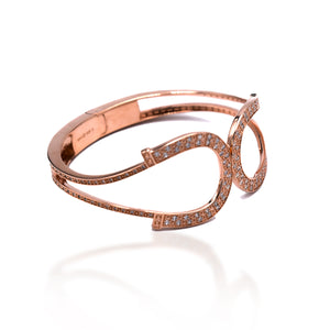 The Kelly Herd Rose Gold Double Horseshoe Bangle Bracelet is Sterling Silver plated with Rose Gold and enhanced with clear Cubic Zirconia stones. It features a hinged opening for easy wear.  Features      Rose Gold Plated     Enhanced with clear cubic zirconia stones     Sterling Silver   