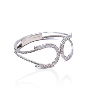 The Kelly Herd Double Horseshoe Bangle Bracelet is made of Sterling Silver and enhanced with clear Cubic Zirconia stones. It features a hinged opening for easy wear.  Features      Double Horseshoe Design     Enhanced with clear cubic zirconia stones     Sterling Silver     Hinged Opening