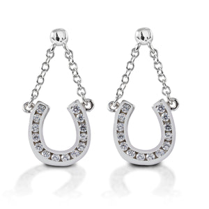 Kelly Herd Horseshoe Dangle Earrings are sterling silver post earrings with cubic zirconia enhanced horseshoes dangling on tiny chains.  These charming equestrian earrings will a bit of sparkle and motion to your style!  Features      Horseshoe motif earrings     Chain dangles     Sterling silver     Clear cubic zirconia