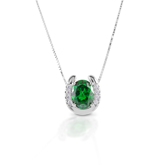 The Kelly Herd Green Stone Horseshoe Necklace features a sterling silver lucky horseshoe enhanced with CZ's, surrounding an oval green stone. The pop of color really makes this simple, but striking necklace stand out. Comes with a 16"-18" adjustable chain.  Features      Horseshoe pendant necklace     Sterling silver     Oval Green CZ     Adjustable 16-18" chain     18mm x 16mm