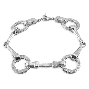 The Kelly Herd Snaffle Bit Bracelet is impeccably designed. You can even see the tiny stitches on the "leather" that connects the bits. Made of sterling silver, and enhanced with CZ.  Features      Snaffle bit bracelet     Enhanced with clear cubic zirconia     Detailed check pieces connecting the bits together     Sterling Silver     17mm x 7 1/4''