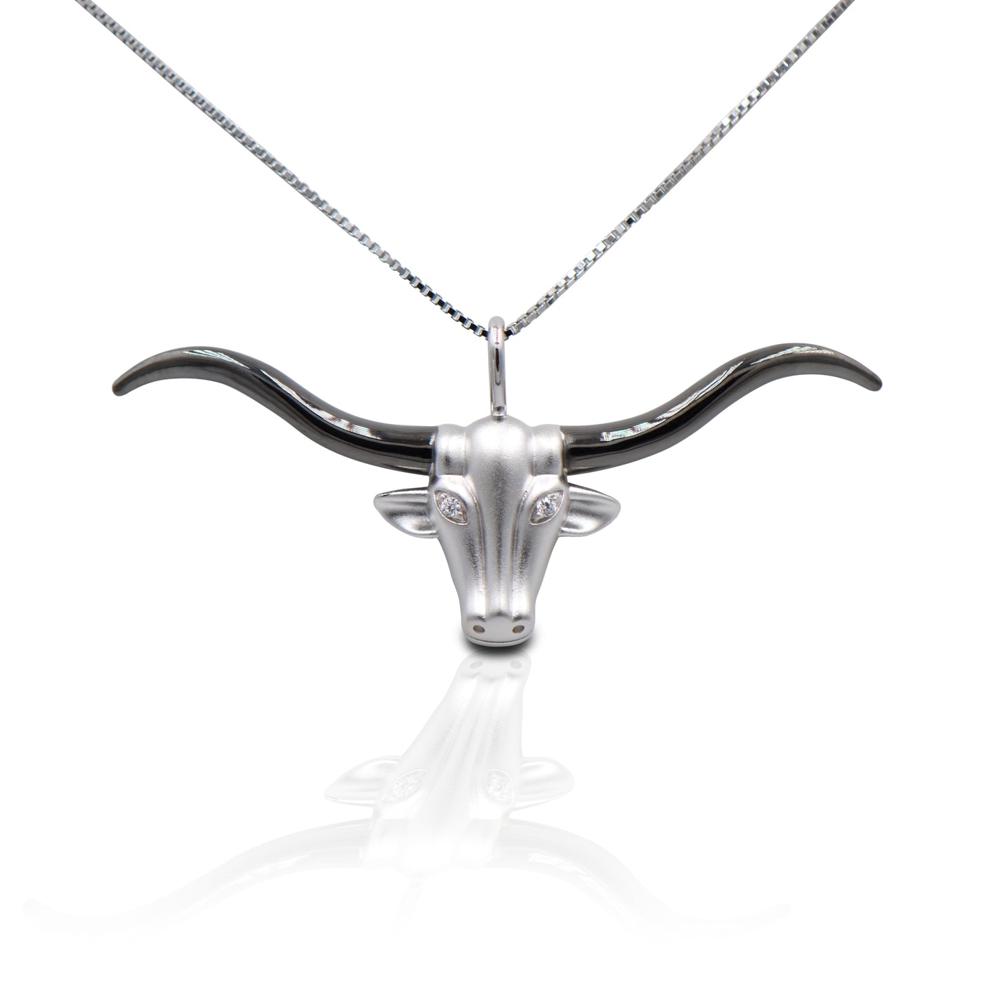 Hook 'Em Horns! The Kelly Herd Large Longhorn Necklace features an incredibly detailed long horn head with a brushed surface and shiny black horns. Made of sterling silver, with clear CZ "eyes" . Comes with adjustable 16-18" chain.  Features      Long horn pendant     Clear CZ stones     Sterling Silver     Comes with adjustable 16-18" chain     41mm x 24mm