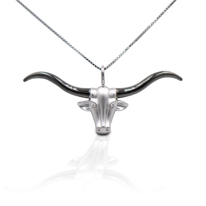 Hook 'Em Horns! The Kelly Herd Large Longhorn Necklace features an incredibly detailed long horn head with a brushed surface and shiny black horns. Made of sterling silver, with clear CZ "eyes" . Comes with adjustable 16-18" chain.  Features      Long horn pendant     Clear CZ stones     Sterling Silver     Comes with adjustable 16-18" chain     41mm x 24mm