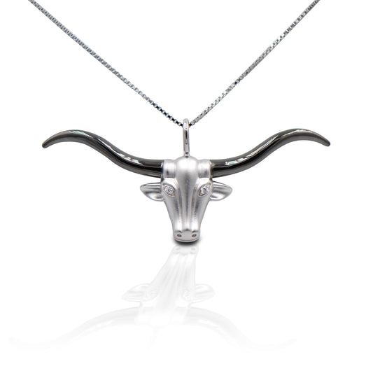 Hook 'Em Horns! The Kelly Herd Large Longhorn Necklace features an incredibly detailed long horn head with a brushed surface and shiny black horns. Made of sterling silver, with clear CZ "eyes" . Comes with adjustable 16-18" chain.  Features      Long horn pendant     Clear CZ stones     Sterling Silver     Comes with adjustable 16-18" chain     41mm x 24mm