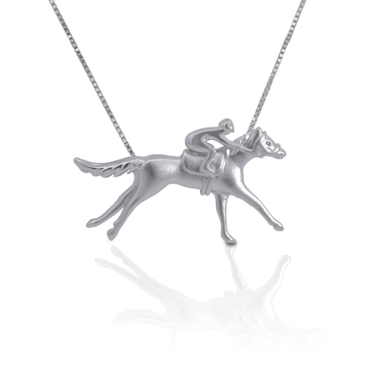 Have a love of horseracing? This little racer pendant is a perfect way to show off your passion on a necklace, or simply enjoy it as a charm. With the rider mounted and racing at full speed, this detailed piece will amaze not just you but all that see it.   Features      Thoroughbred and jockey pendant     Sterling Silver     Comes with adjustable 16-18" chain