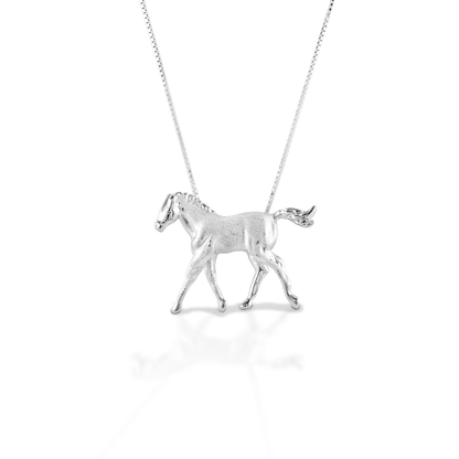 The Kelly Herd Trotting Colt Necklace is made of brushed sterling silver, featuring a beautifully crafted trotting foal. Comes with a 16"-18" adjustable chain.  Features      Trotting foal pendant     Finely detailed, brushed metal     Sterling Silver     28 mm x 27 mm