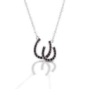 Have double the luck with the Kelly Herd Double Black Horseshoe Necklace. This sterling silver and black cubic zirconia pendant features two overlapping horseshoes enhanced with CZ. Comes with a 16"-18" adjustable chain.  Features      Double Horseshoe pendant     Sterling Silver     Black cubic zirconia stones     15 mm x13 mm