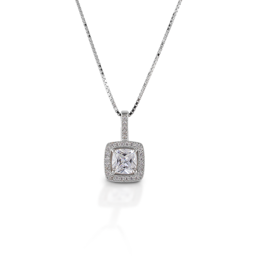The Kelly Herd Square Bezel Set Pave Necklace is made of sterling silver with a round bezel set CZ stone. At 10mm, this pendant is the perfect size. Elegant, but not over-powering. Comes with a 16"-18" adjustable chain. Matching earrings are available.  Features      Square bezel set pendant     Sterling Silver     Clear CZ stones     10 mm